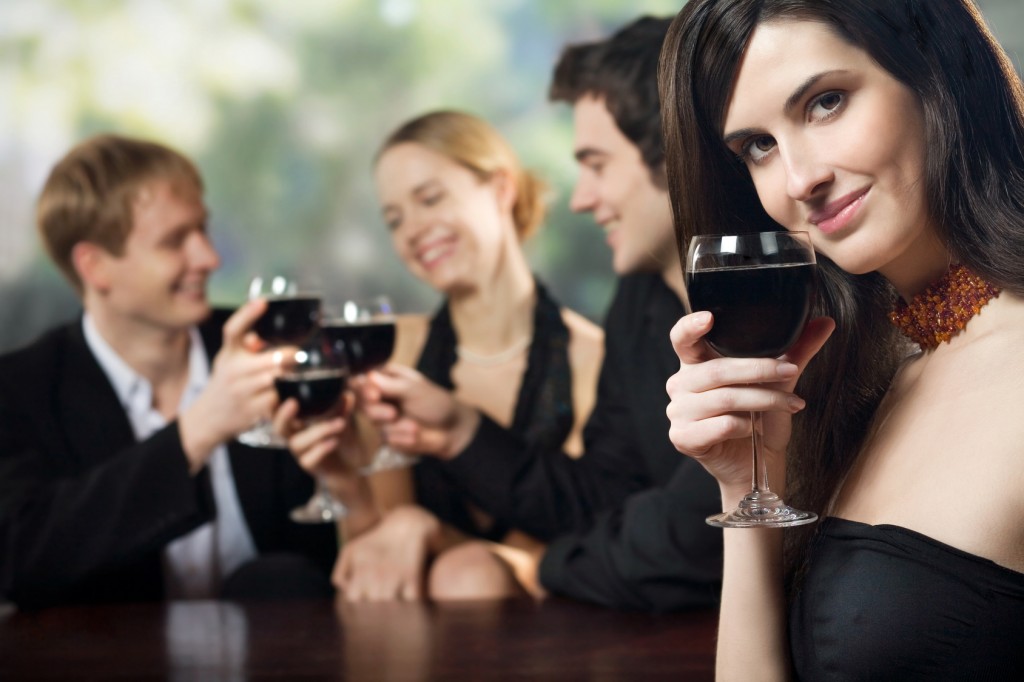Two young couples with red wine at celebration or party